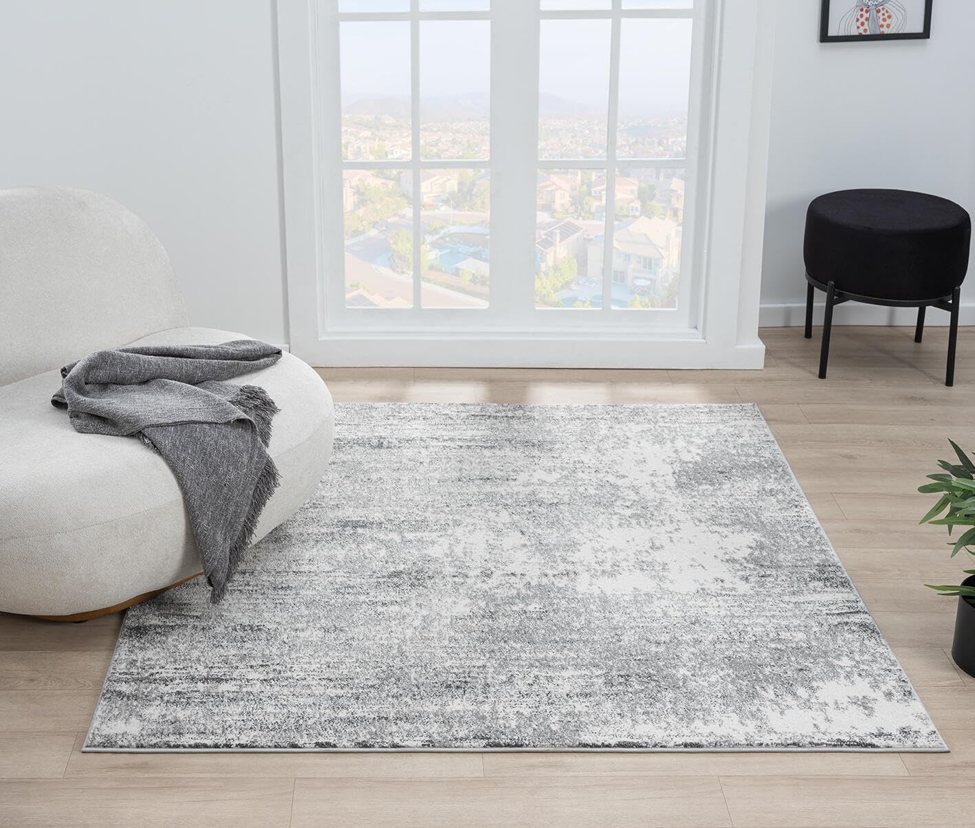 Cream rug under a navy sofa with light wood furniture