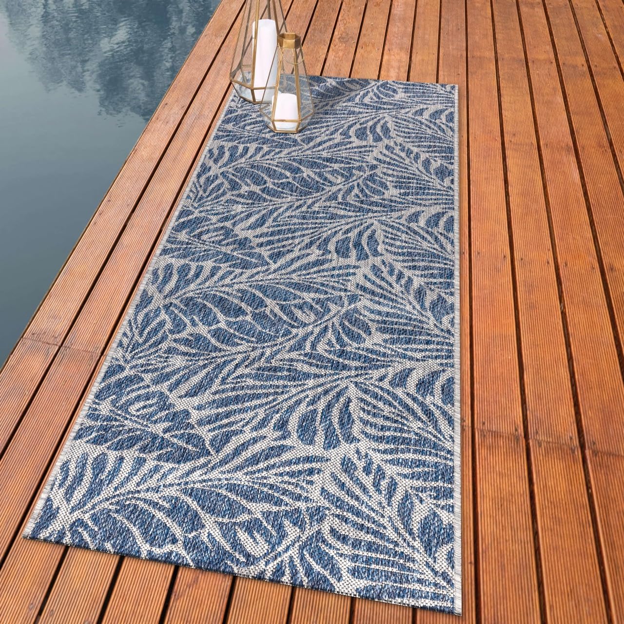 Botanical palm leaf outdoor rug styled with rattan dining furniture
