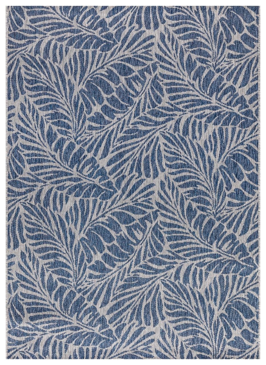 Navy and gray tropical leaf outdoor rug on covered teak patio