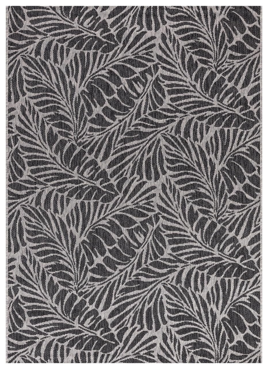 Black and gray tropical leaf outdoor rug on covered teak patio