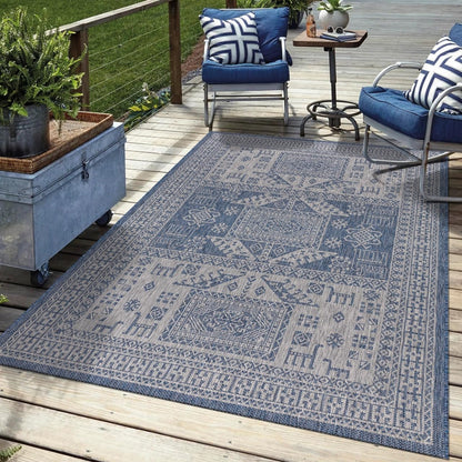 Navy tribal outdoor rug in garden seating area with greenery
