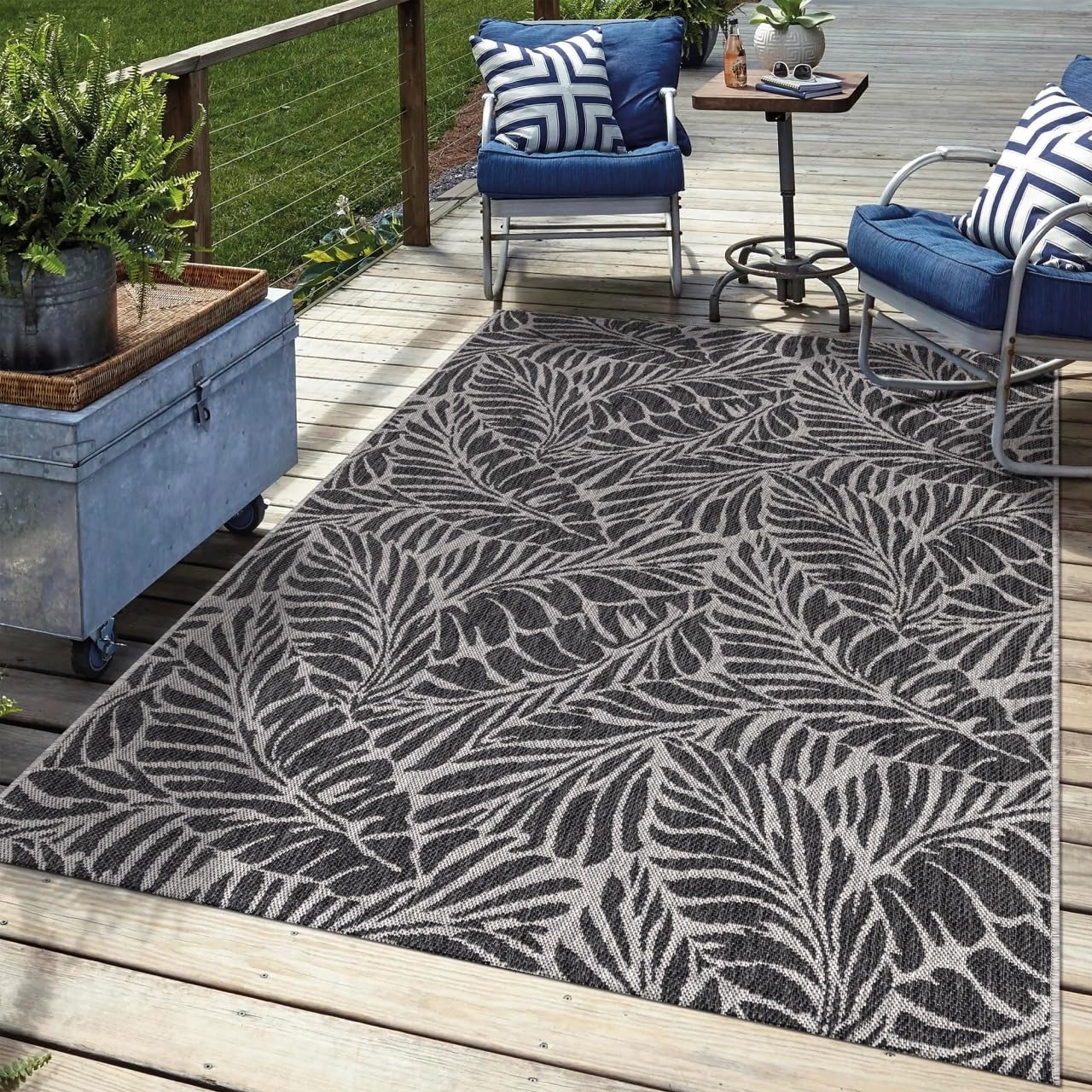 Black tropical outdoor rug in garden seating area with greenery