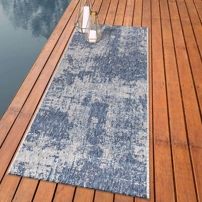 Distressed painterly outdoor rug styled with outdoor dining furniture