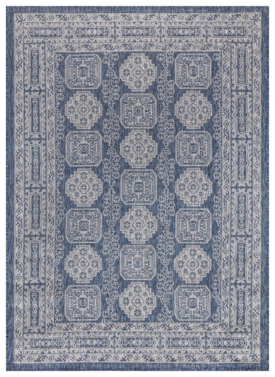 Navy and ivory Anatolian medallion outdoor rug on covered teak patio