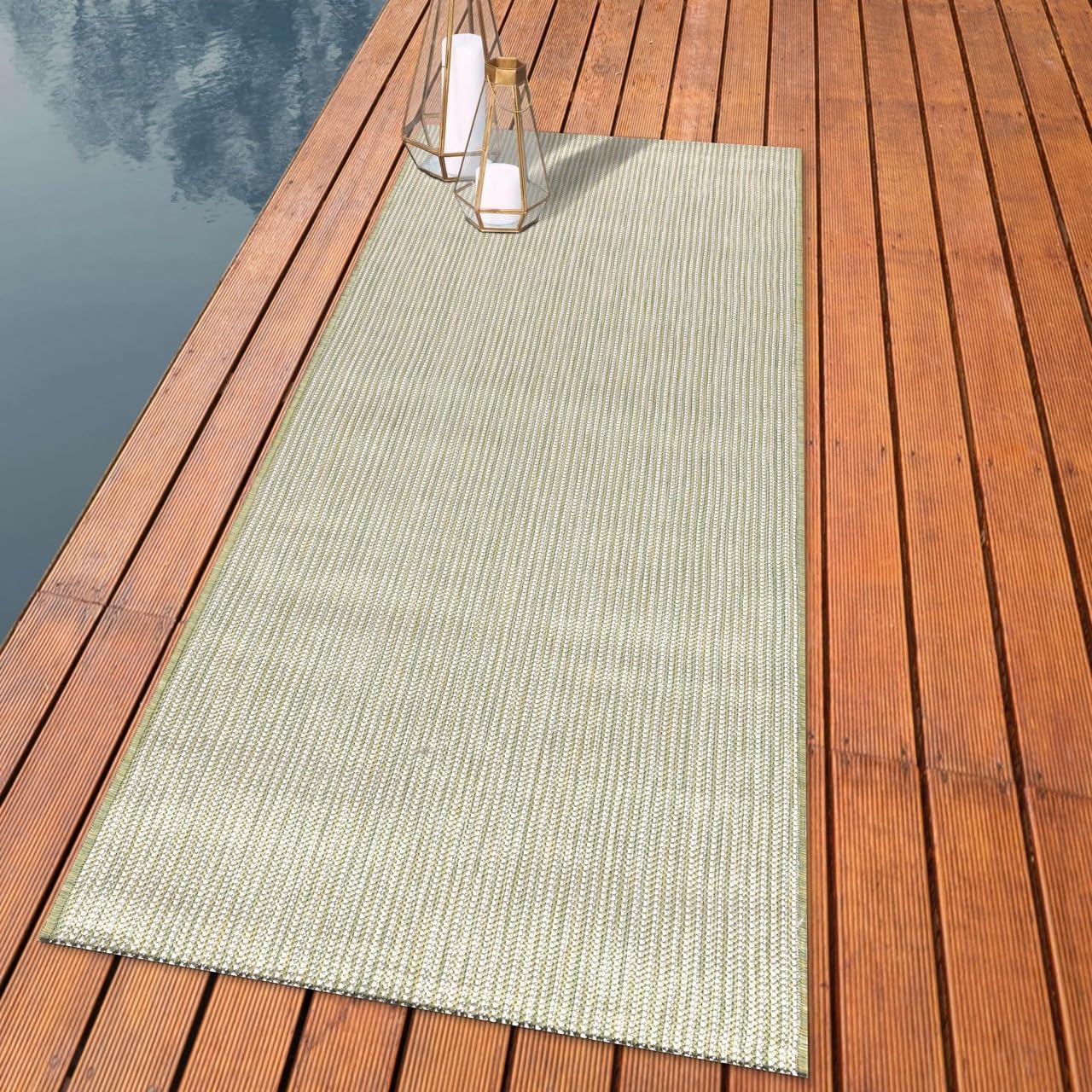 Solid green outdoor rug styled with modern dining furniture