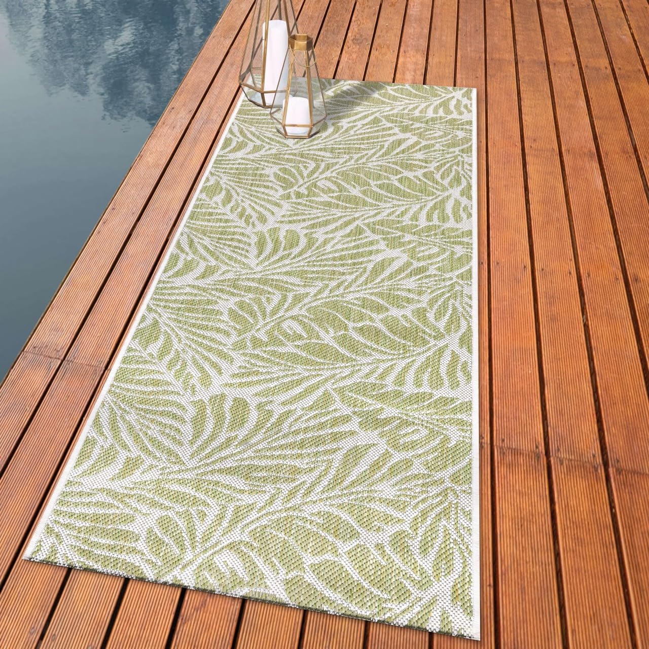Botanical palm leaf outdoor rug styled with rattan dining furniture
