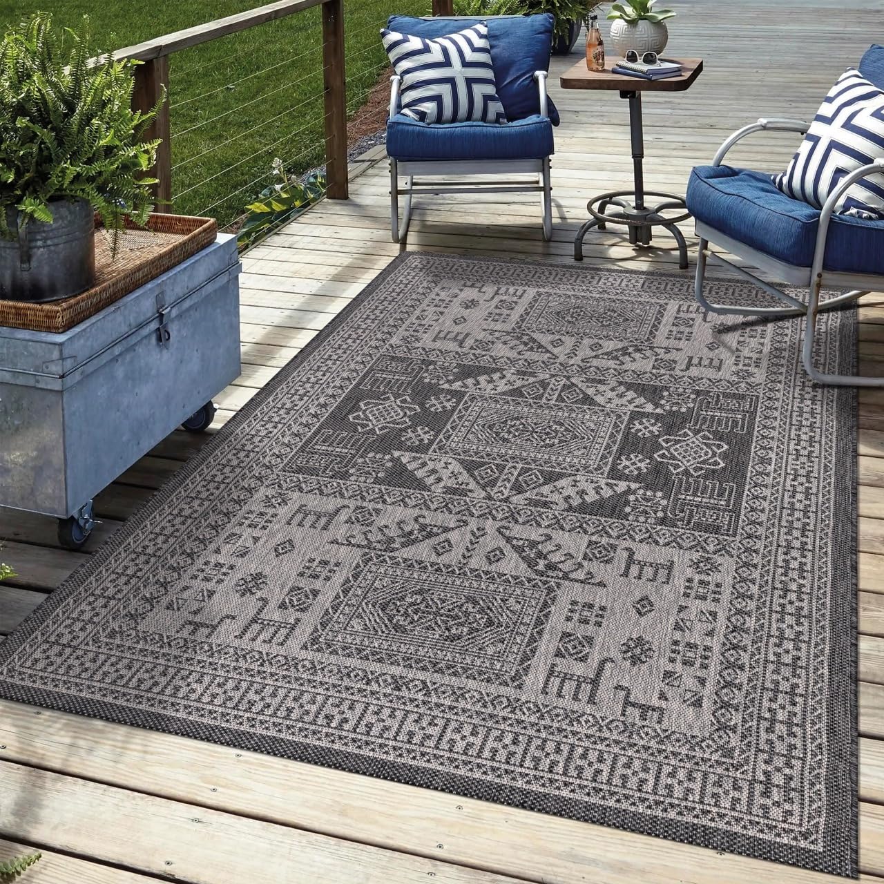 Black tribal outdoor rug in garden seating area with greenery