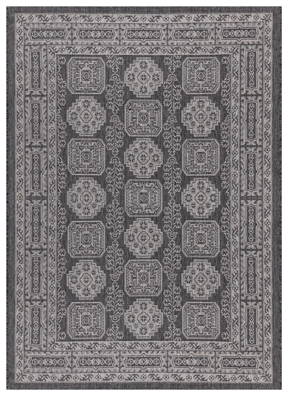 Black and gray Anatolian medallion outdoor rug on covered teak patio