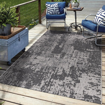 Black abstract outdoor rug in garden seating area with greenery