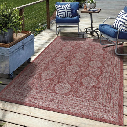 Terracotta Turkmen rug in three-season sunroom with rattan furniture