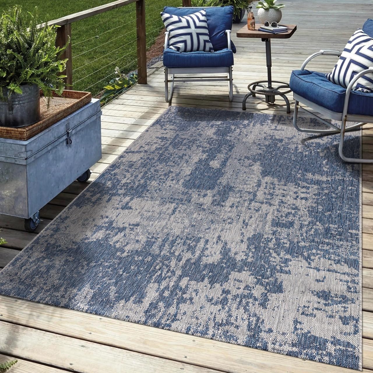 Navy abstract outdoor rug in garden seating area with greenery