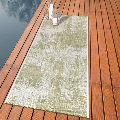 Distressed painterly outdoor rug styled with outdoor dining furniture