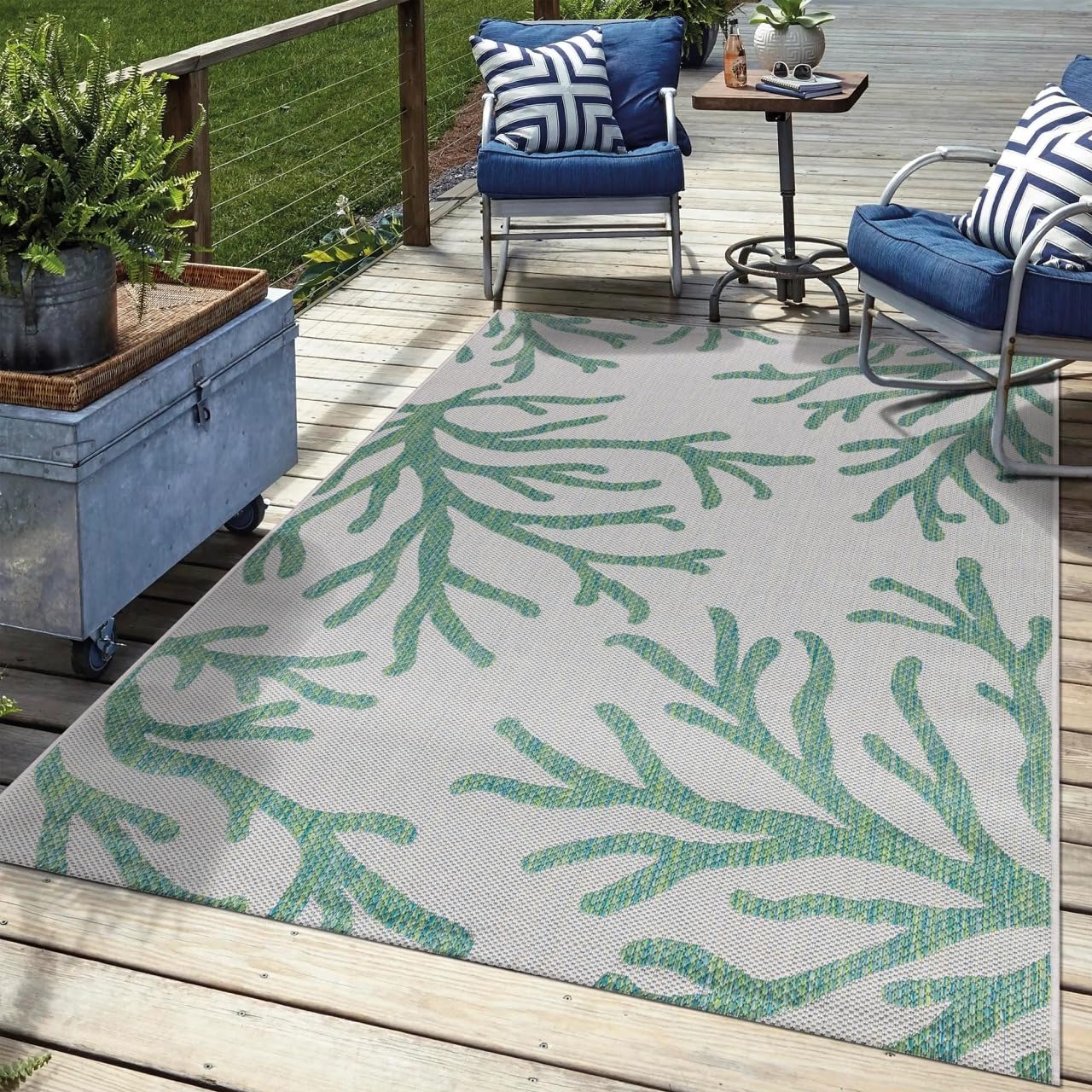 Green coral outdoor rug in garden seating area with greenery