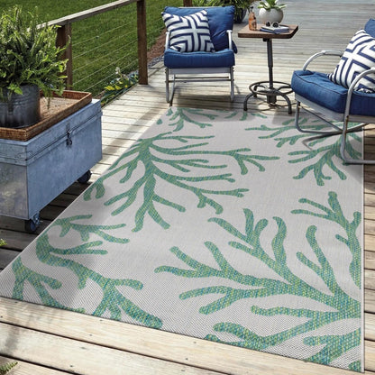 Green coral outdoor rug in garden seating area with greenery