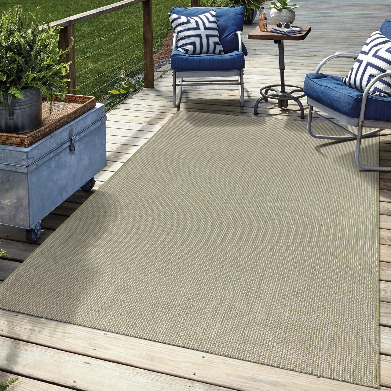 Solid green outdoor rug in garden seating area with greenery
