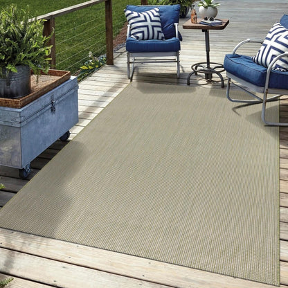 Solid green outdoor rug in garden seating area with greenery