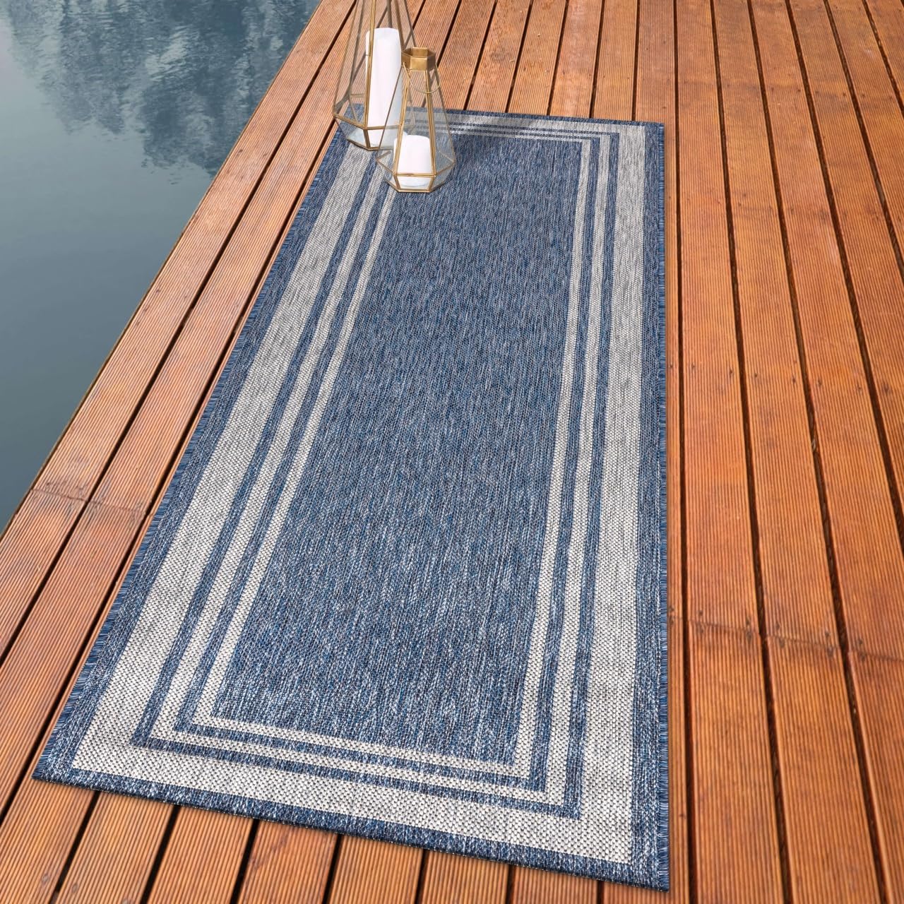 Coastal bordered outdoor rug styled with white-frame dining furniture