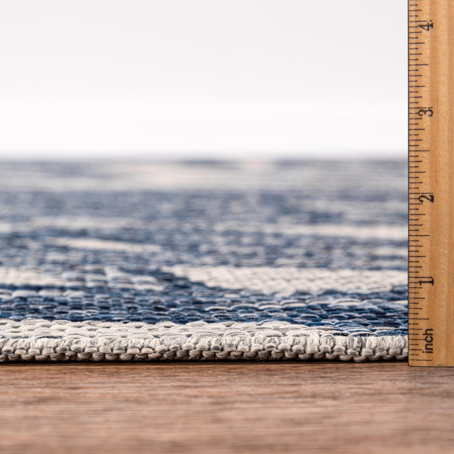 Bound edge detail of the navy tropical jungle outdoor rug