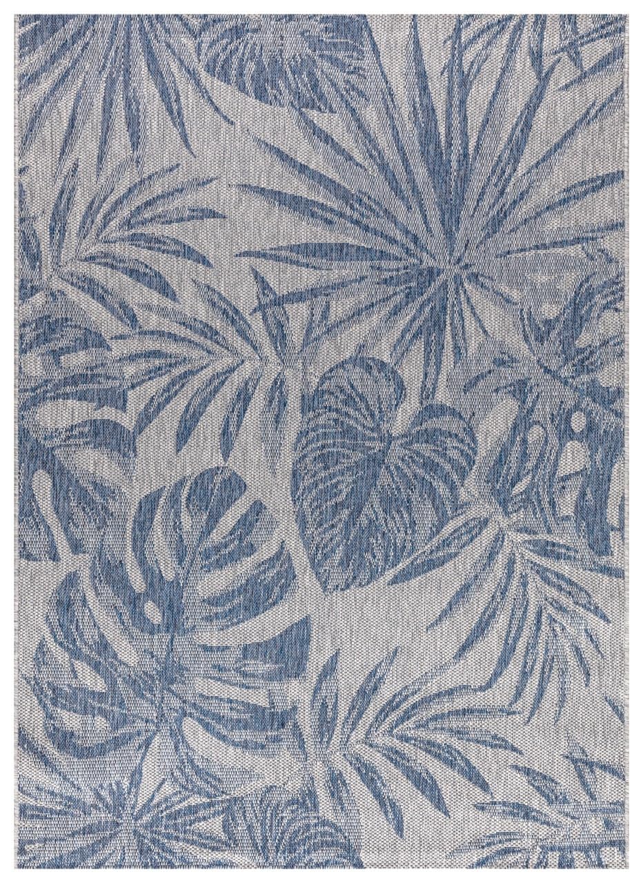 Navy and ivory tropical jungle outdoor rug on covered teak patio