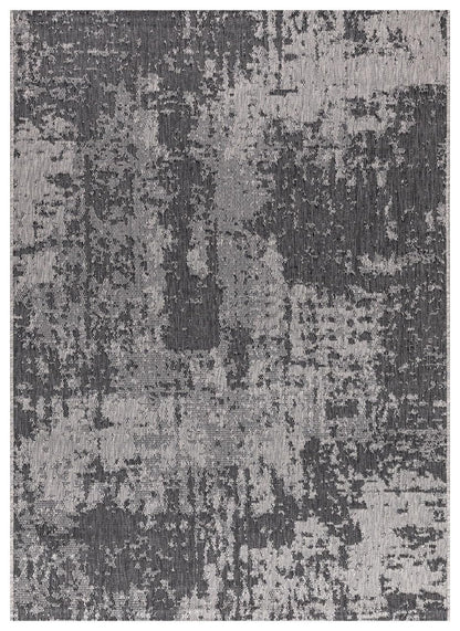 Black and ivory modern abstract outdoor rug on covered teak patio