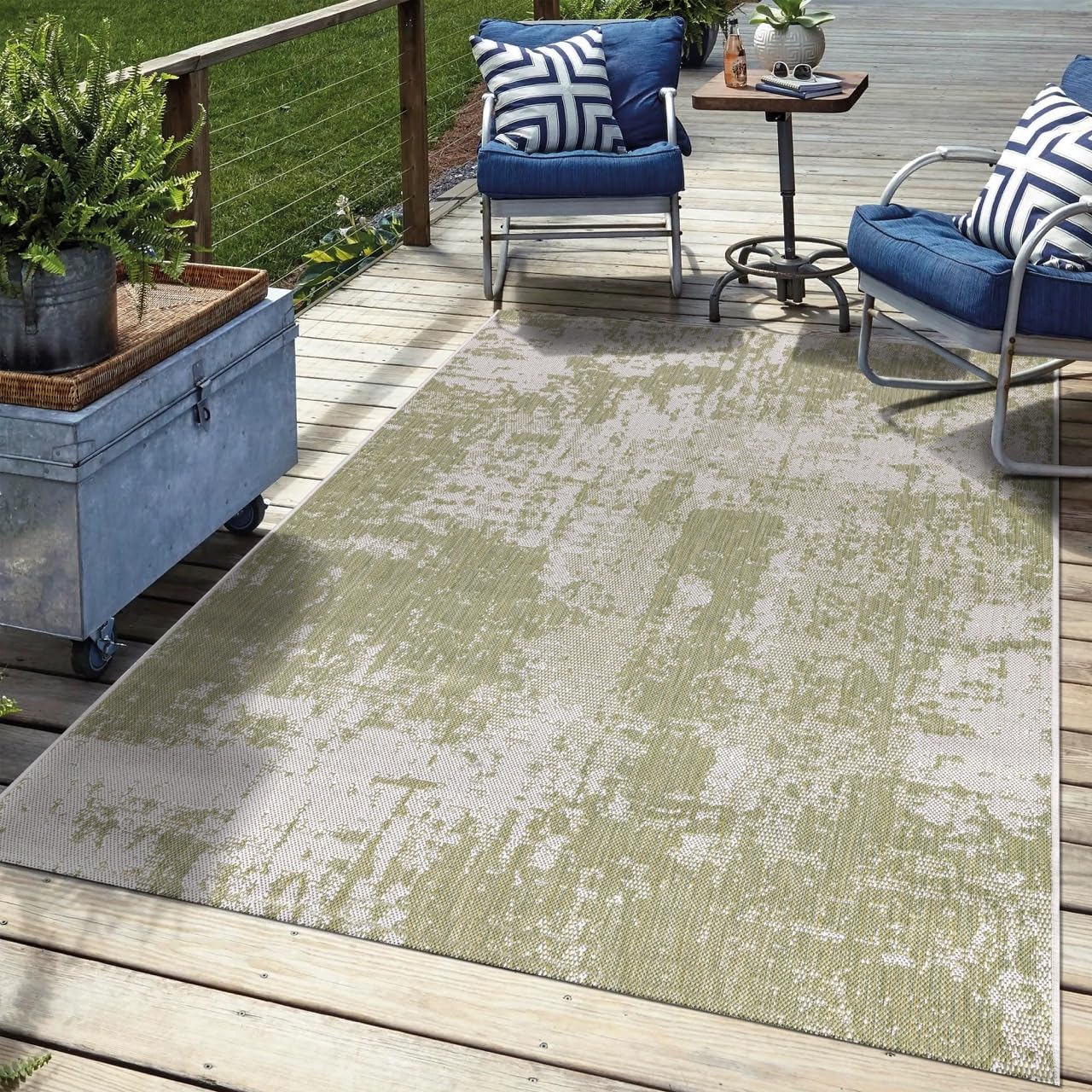 Green abstract outdoor rug in garden seating area with greenery