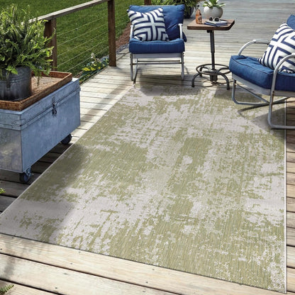 Green abstract outdoor rug in garden seating area with greenery