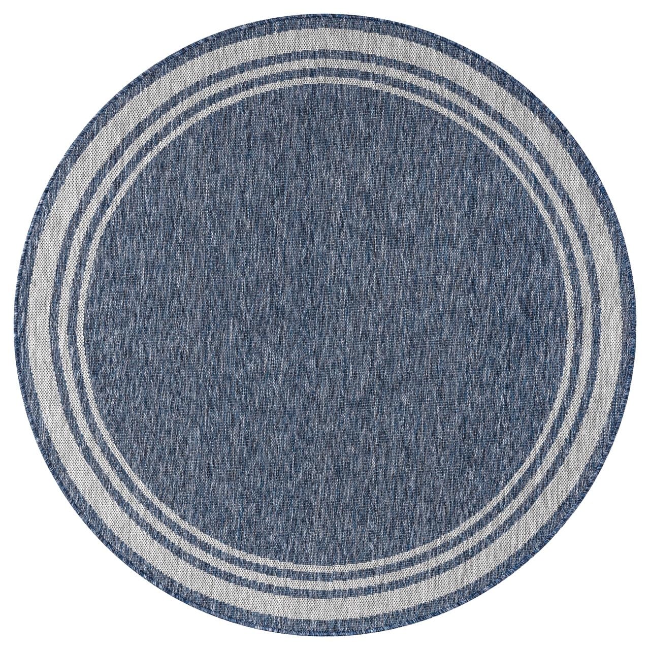 Navy and ivory bordered rug in beach house screened porch setting