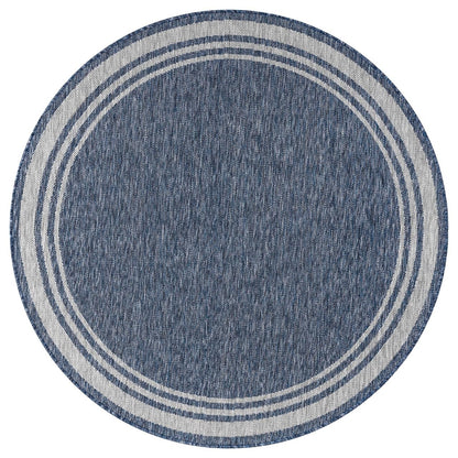 Navy and ivory bordered rug in beach house screened porch setting