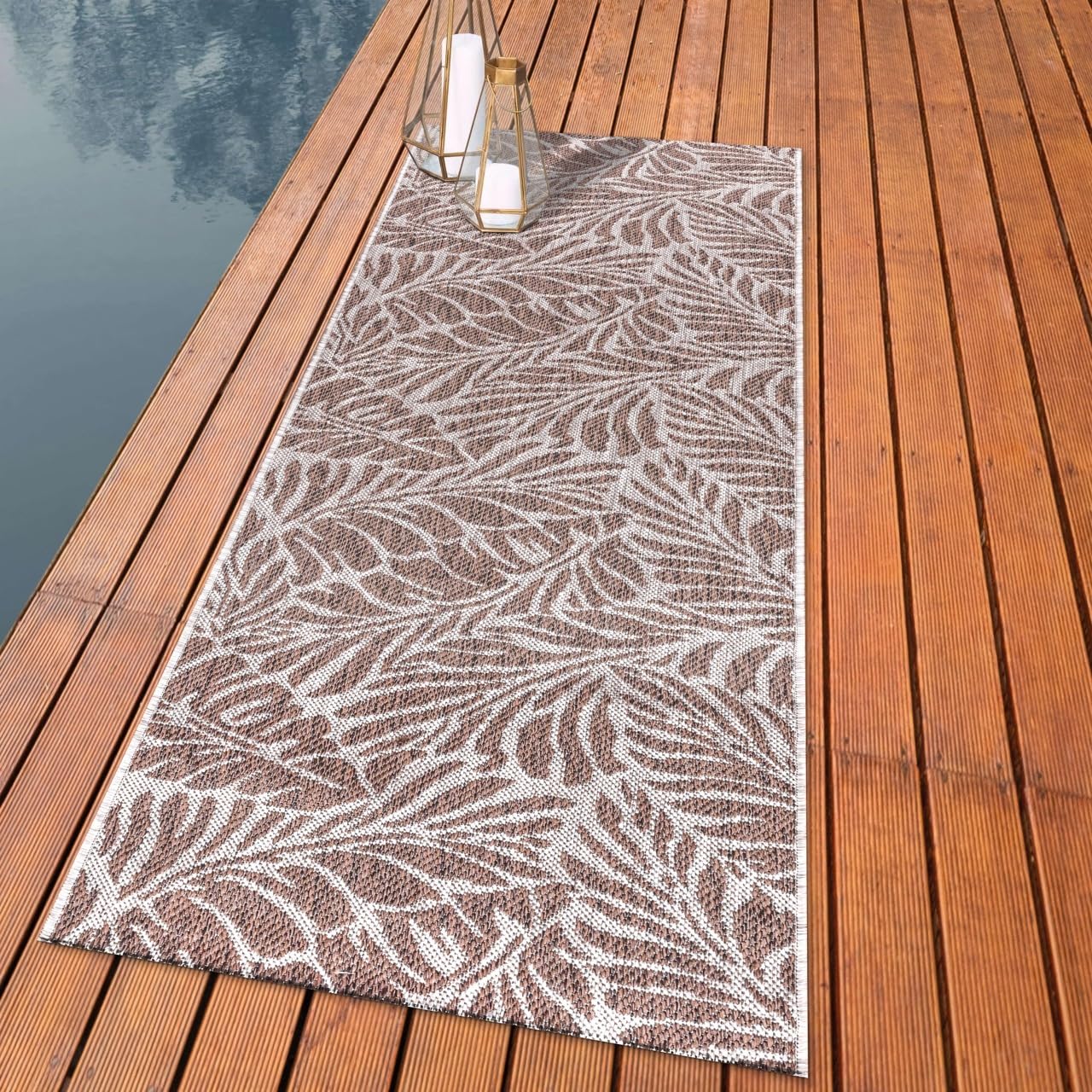 Botanical palm leaf outdoor rug styled with rattan dining furniture
