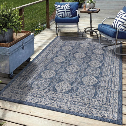 Navy Anatolian outdoor rug in garden seating area with greenery