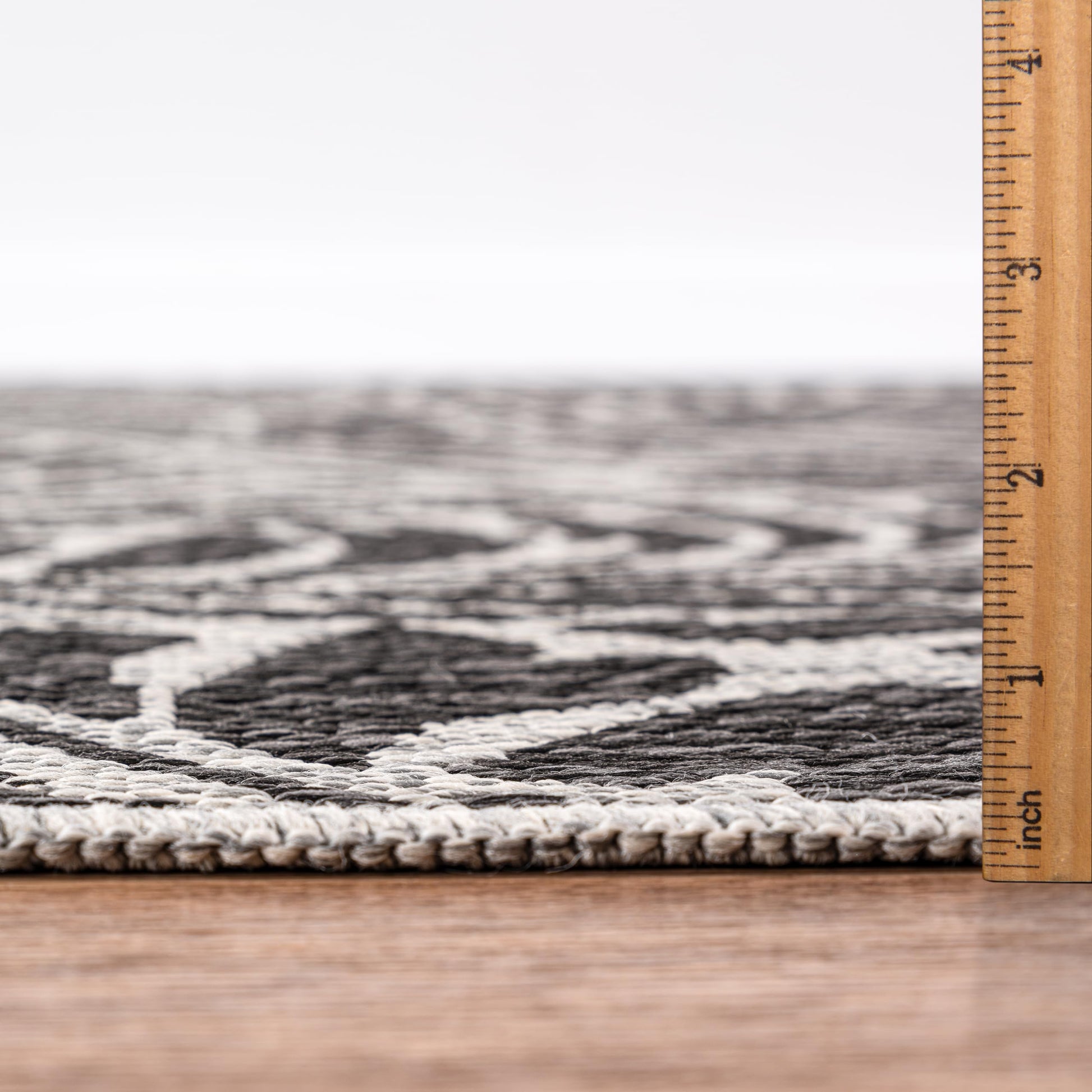 Bound edge detail of the Black tropical leaf outdoor rug