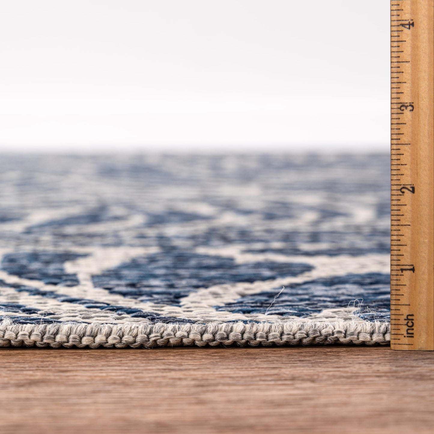 Bound edge detail of the Navy tropical leaf outdoor rug