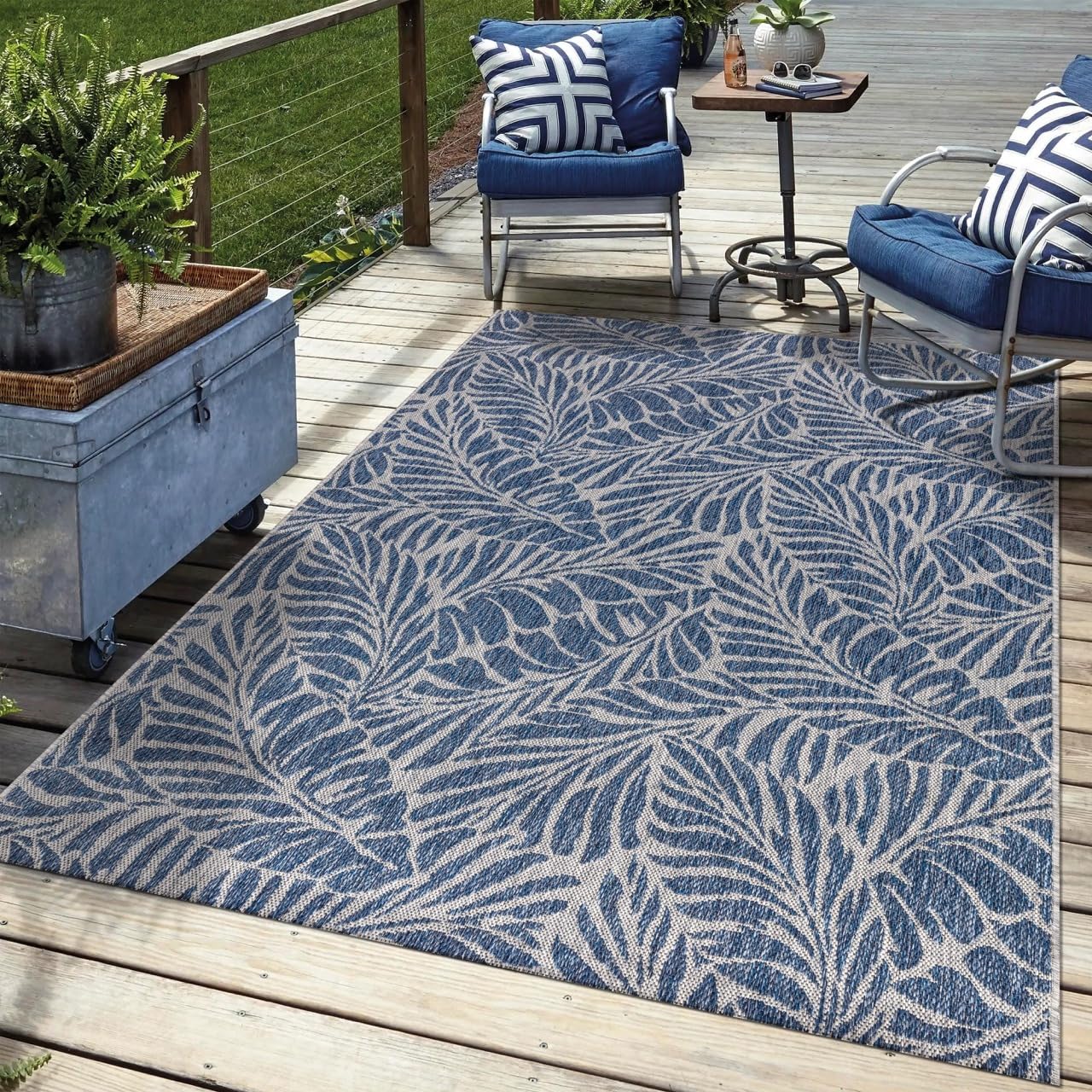 Navy tropical outdoor rug in garden seating area with greenery