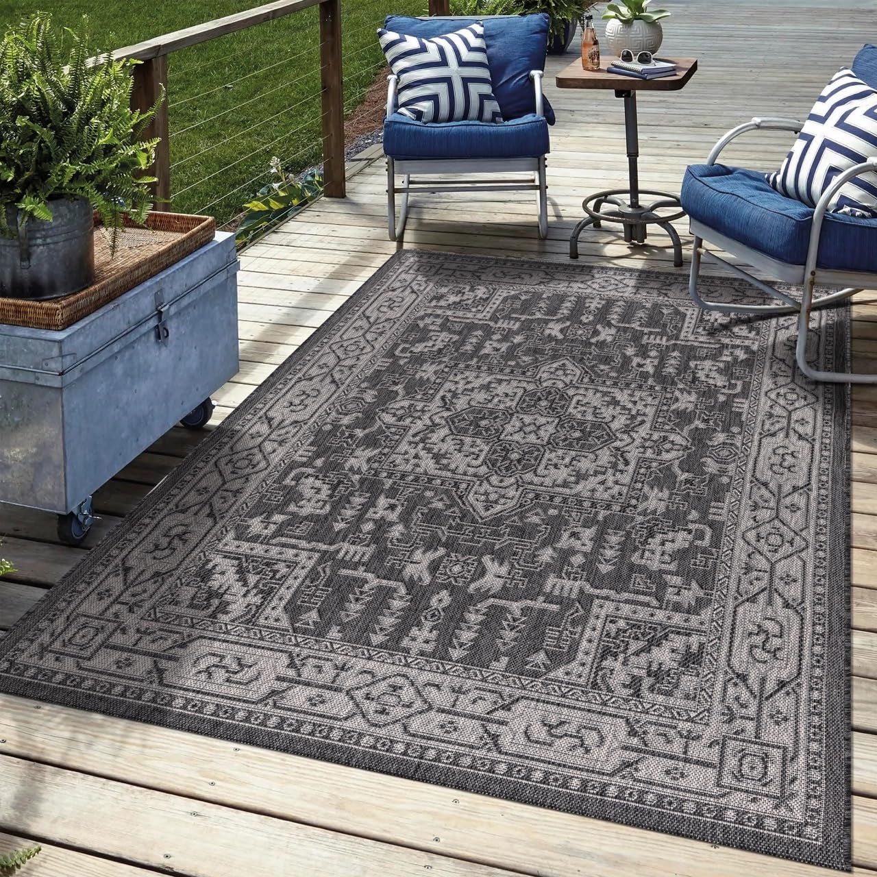 Black Heriz outdoor rug in garden seating area with greenery