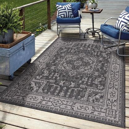 Black Heriz outdoor rug in garden seating area with greenery