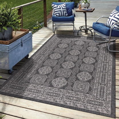 Black Anatolian outdoor rug in garden seating area with greenery