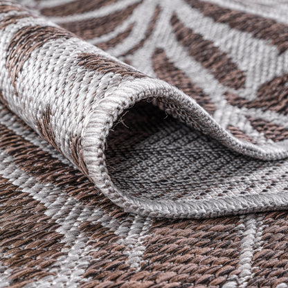 Brown botanical rug in three-season sunroom with rattan furniture