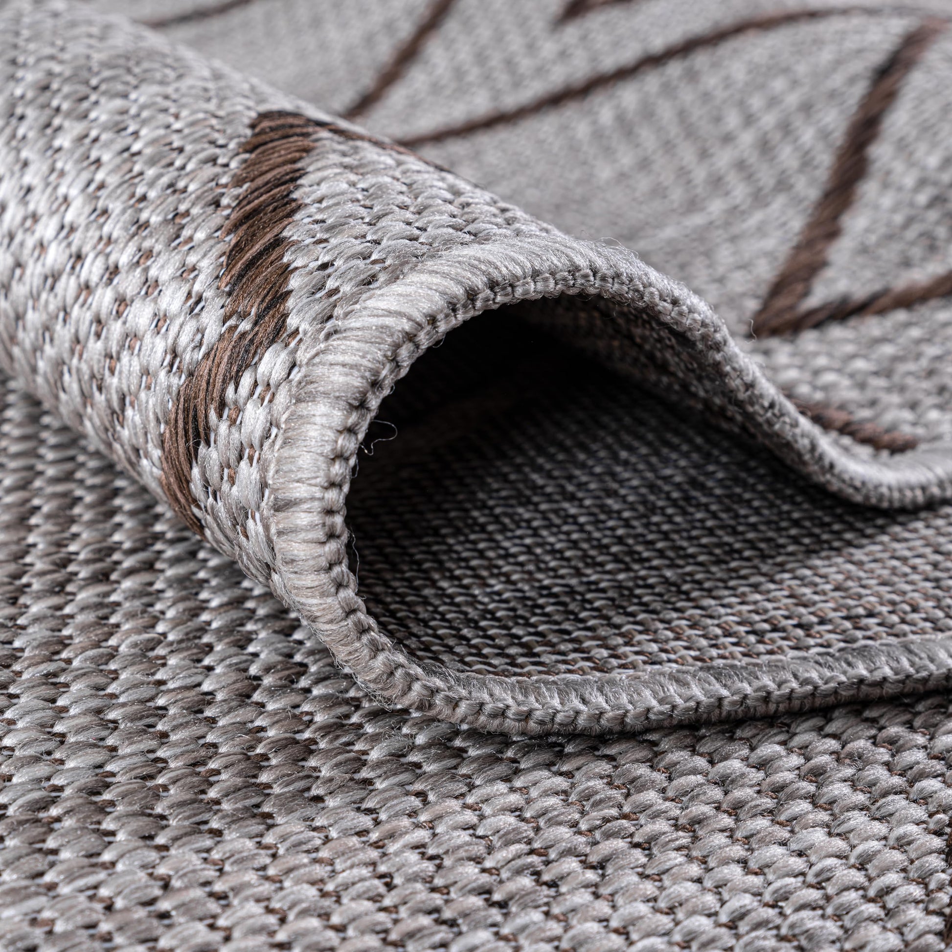 Brown Moroccan rug in three-season sunroom with rattan furniture