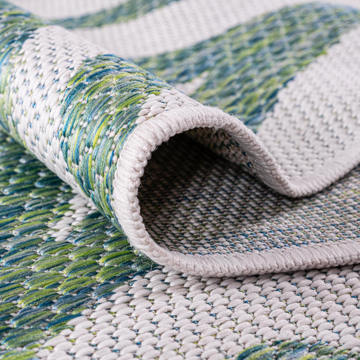 Green coral coastal rug in three-season sunroom with white furniture