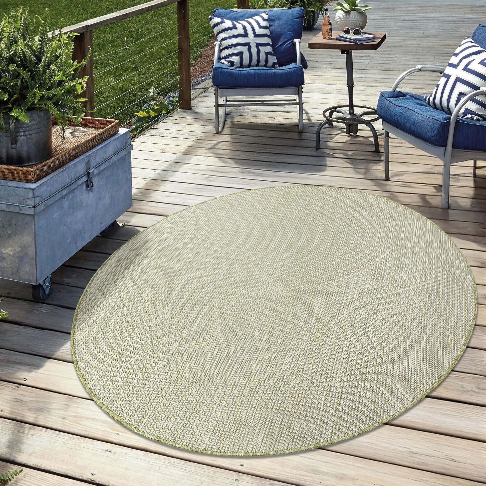 Solid green weatherproof rug on cedar deck with lounge chairs