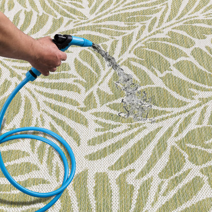 Green botanical patio rug under bistro table with chairs