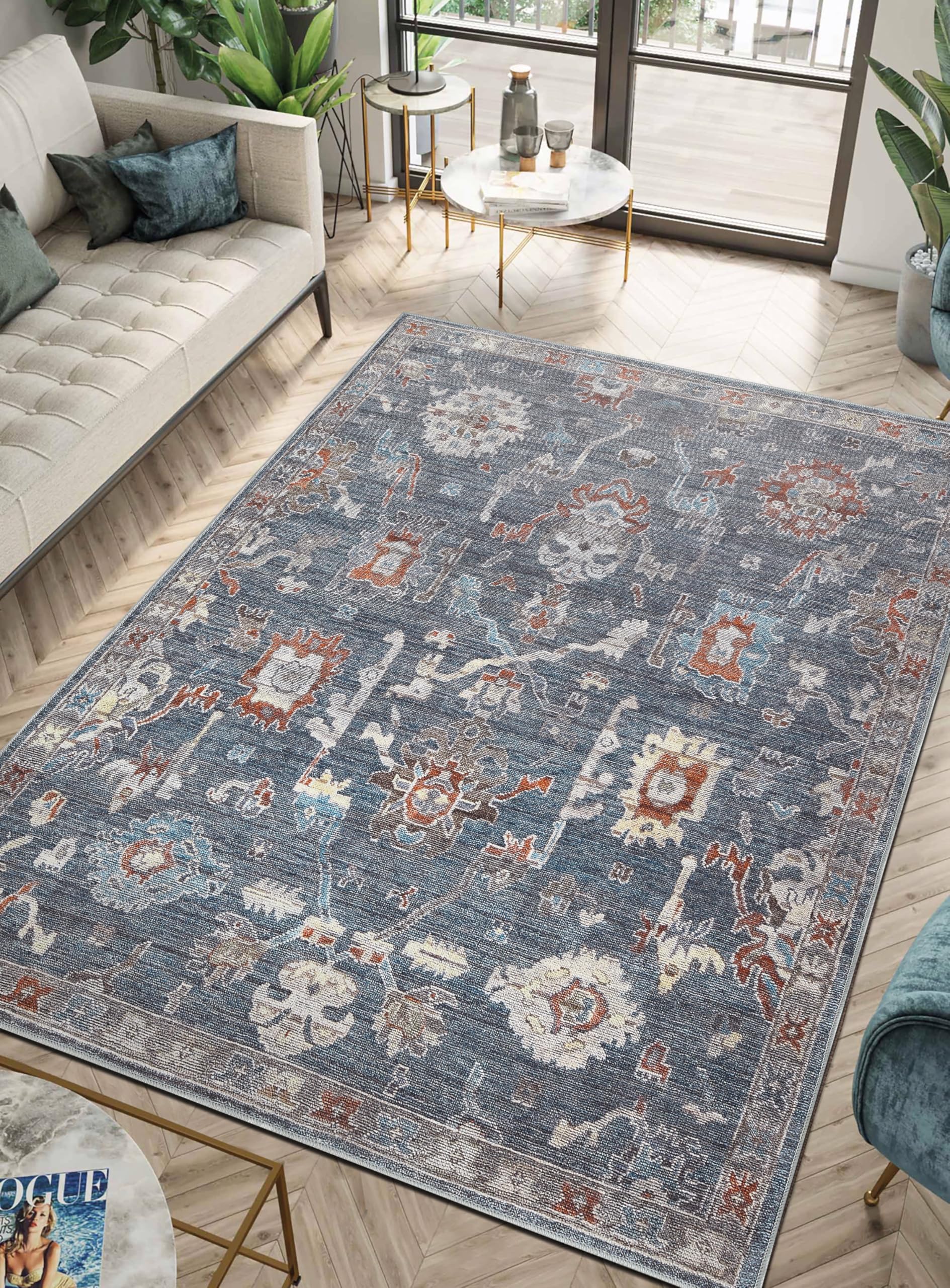 Charcoal Farahan rug under a leather chesterfield sofa with brass accents