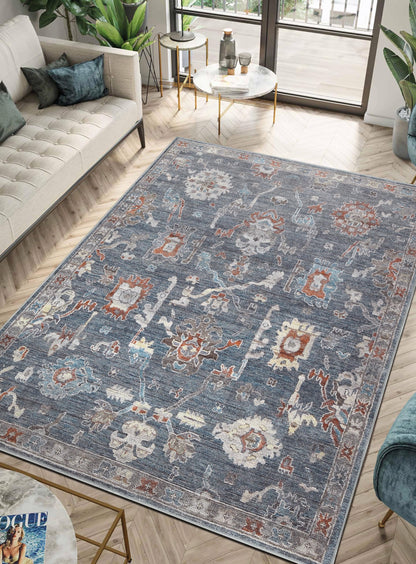 Charcoal Farahan rug under a leather chesterfield sofa with brass accents