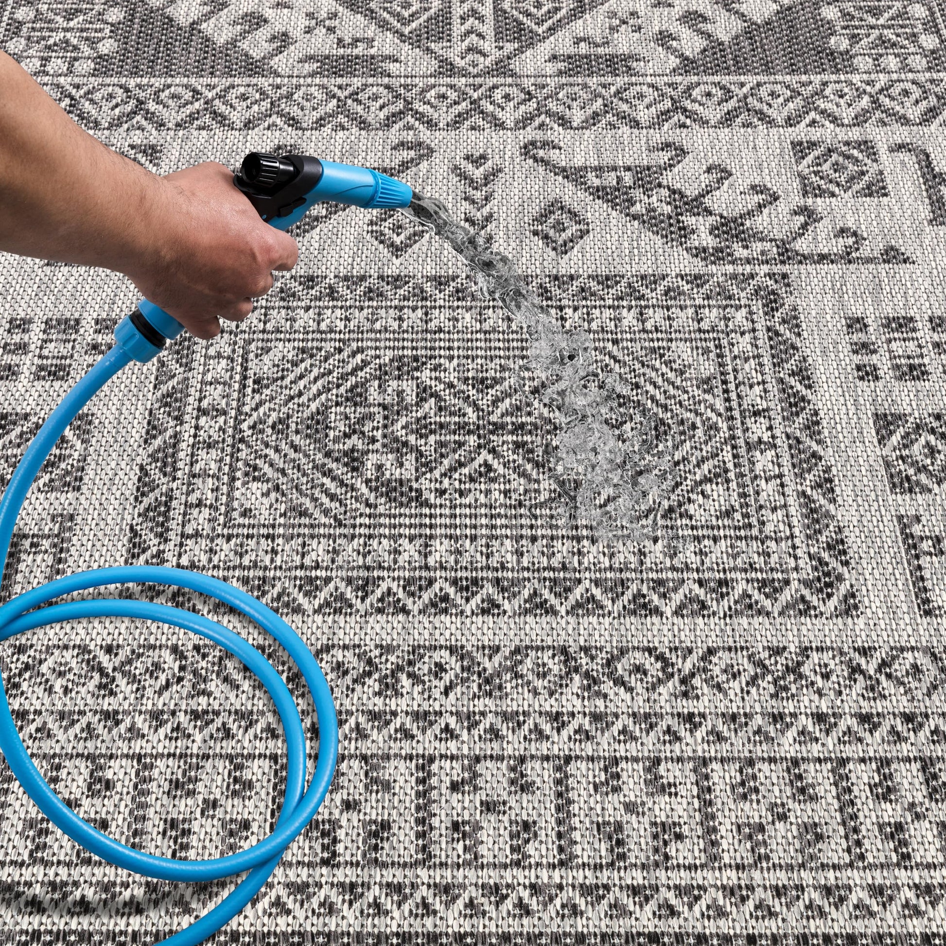 Black tribal patio rug under bistro table with chairs