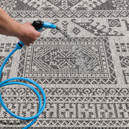 Black tribal patio rug under bistro table with chairs