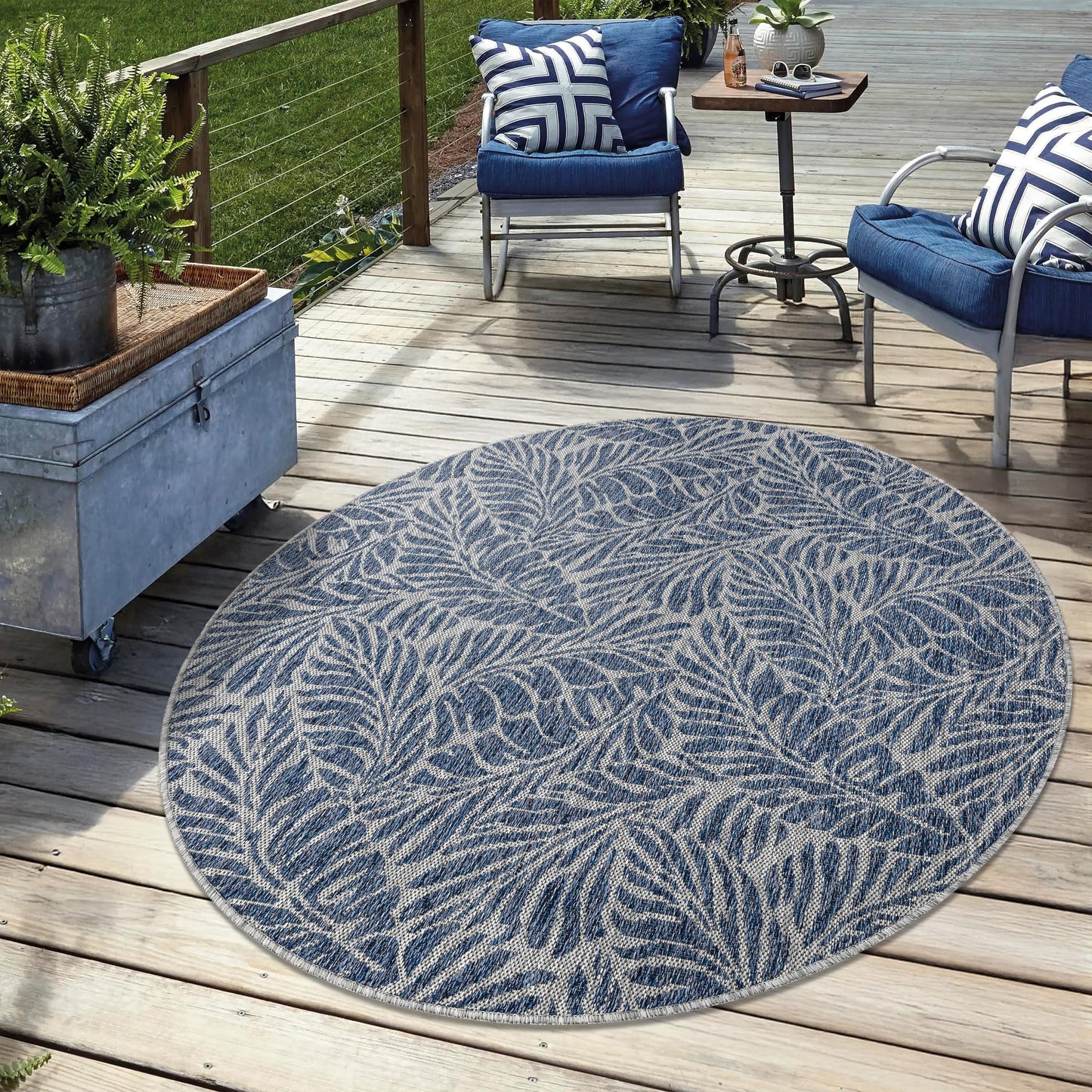 Navy weatherproof botanical rug on cedar deck with lounge chairs