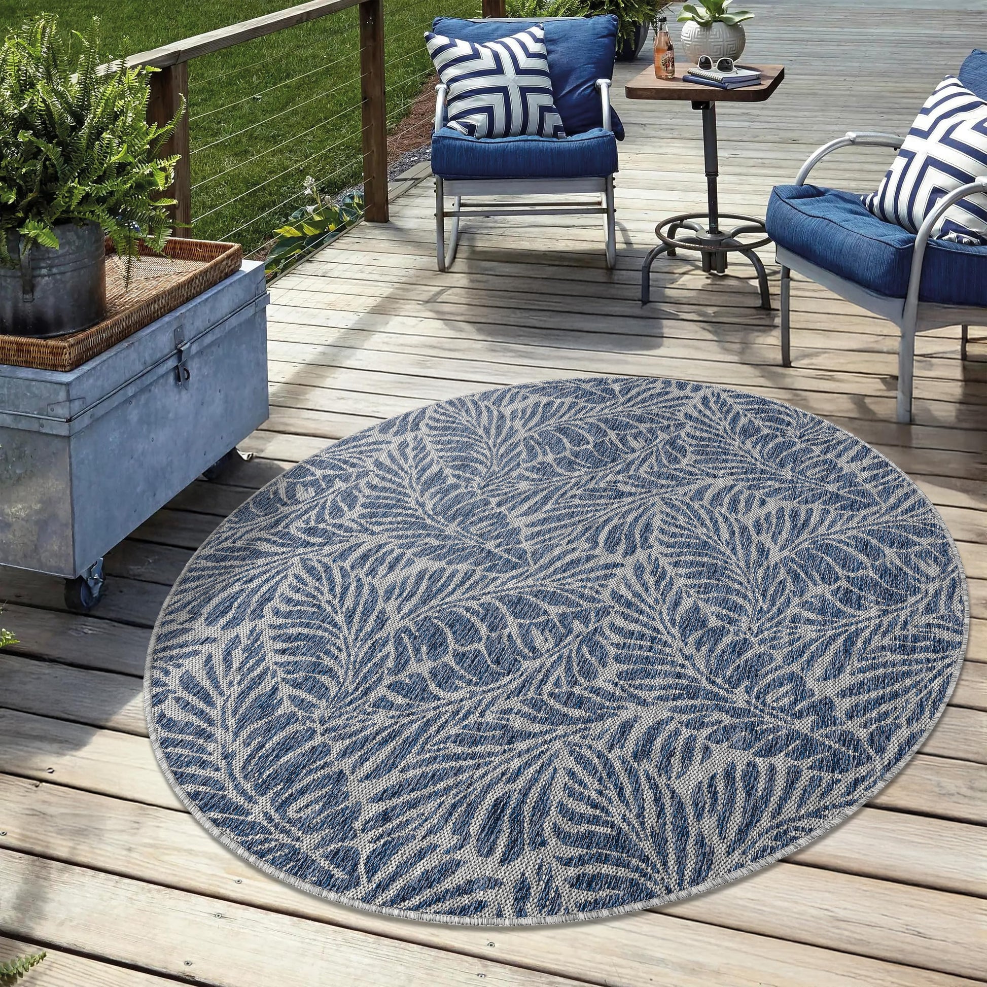 Navy weatherproof botanical rug on cedar deck with lounge chairs