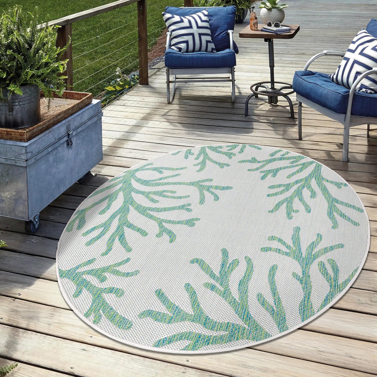 Green coastal weatherproof rug on cedar deck with lounge chairs