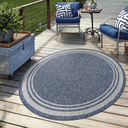 Navy bordered weatherproof rug on cedar deck with lounge chairs