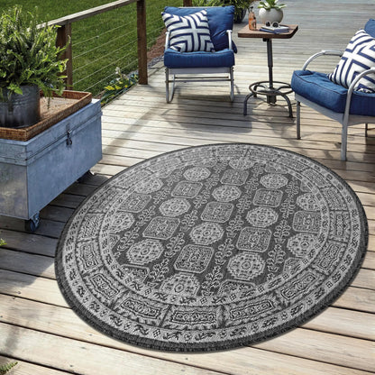 Black weatherproof Anatolian rug on cedar deck with lounge chairs